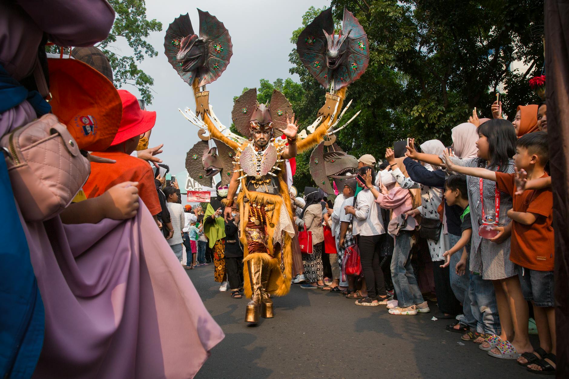 Vibrant cultural parade in Bandung, Indonesia, featuring a performer in elaborate traditional costume.