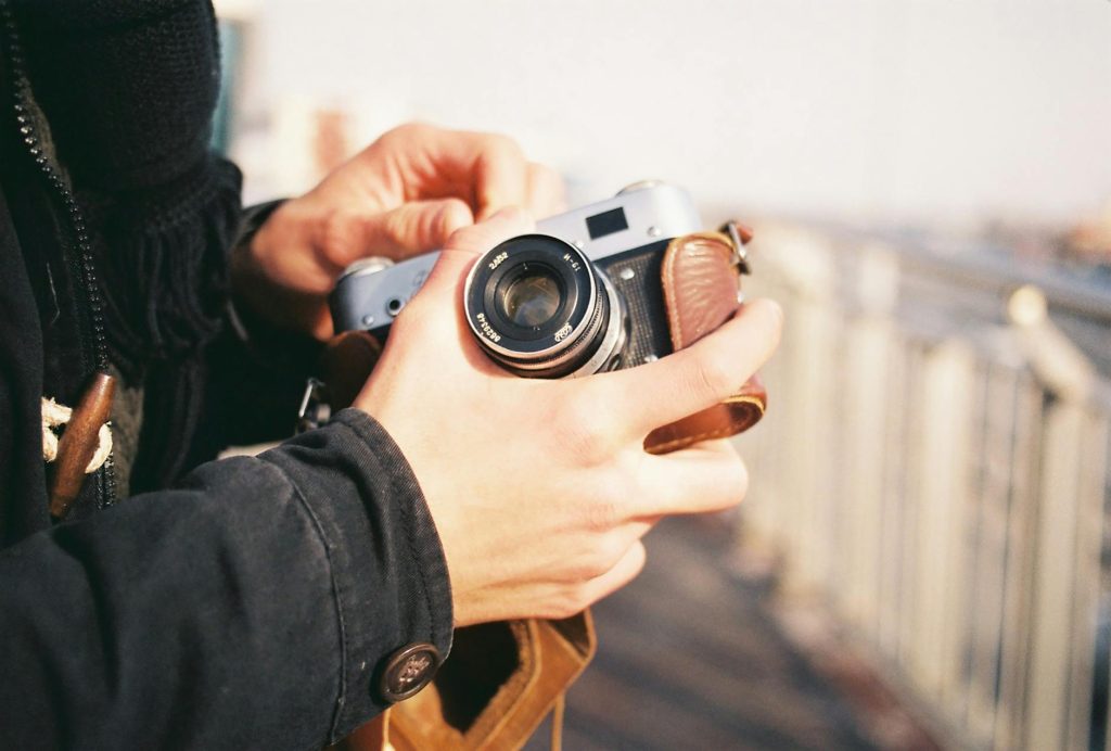 Close-up of hands holding a vintage camera in an outdoor setting in Istanbul.
