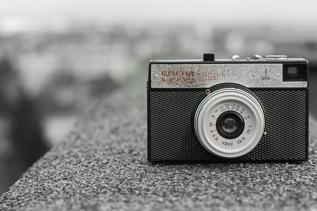 Classic vintage camera resting on a rough concrete surface, showcasing Soviet design.