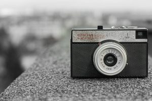 Classic vintage camera resting on a rough concrete surface, showcasing Soviet design.