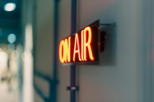 Bright red 'On Air' neon sign captured indoors, ideal for media content.