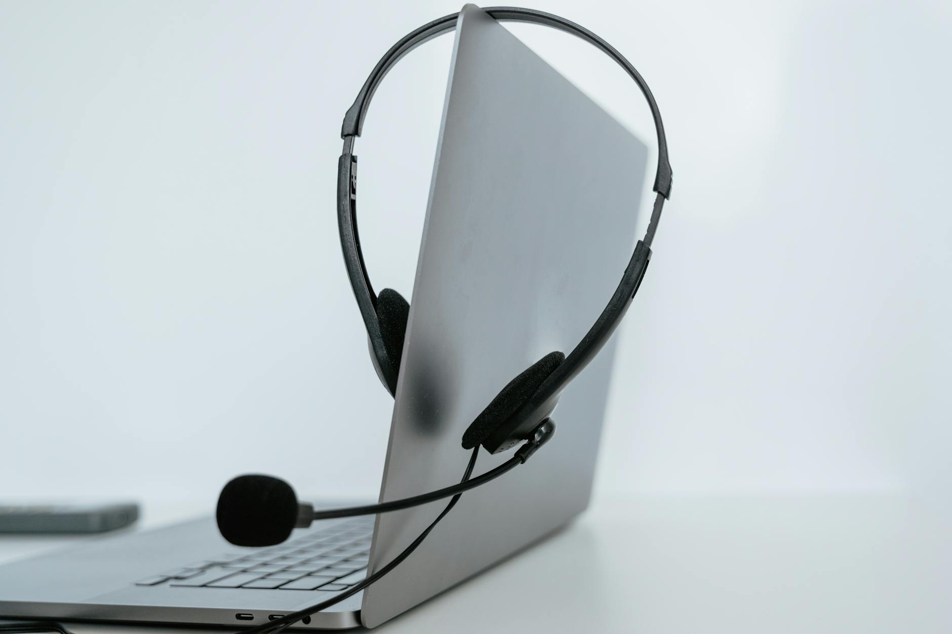 Close-up of a laptop with a headset, symbolizing remote work or online communication.
