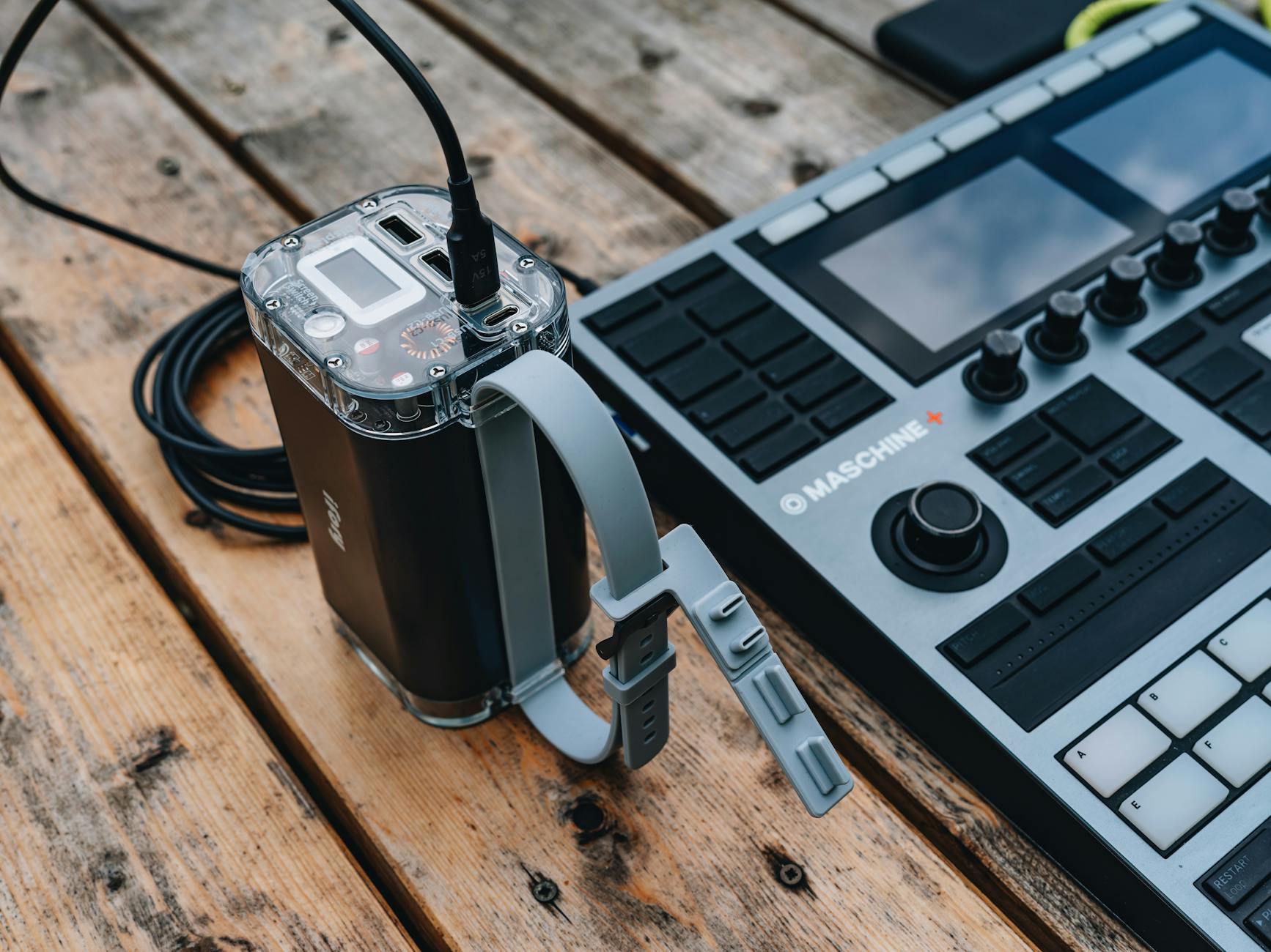 Sound mixer and power supply on a wooden table, ideal for music production setups.