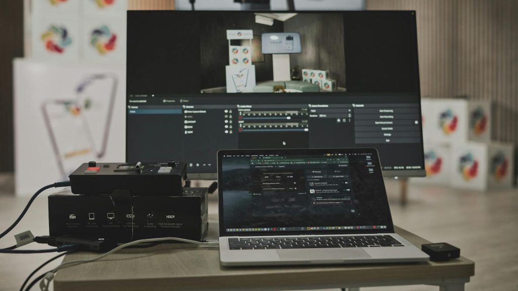 Multimedia setup featuring a laptop and a large monitor in a tech-savvy workspace.