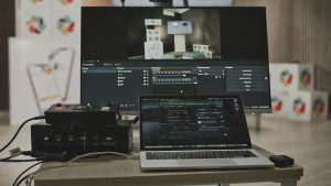 Multimedia setup featuring a laptop and a large monitor in a tech-savvy workspace.