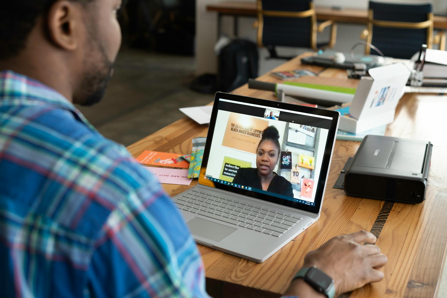 A businessman engaging in a virtual meeting using a laptop at an office desk.