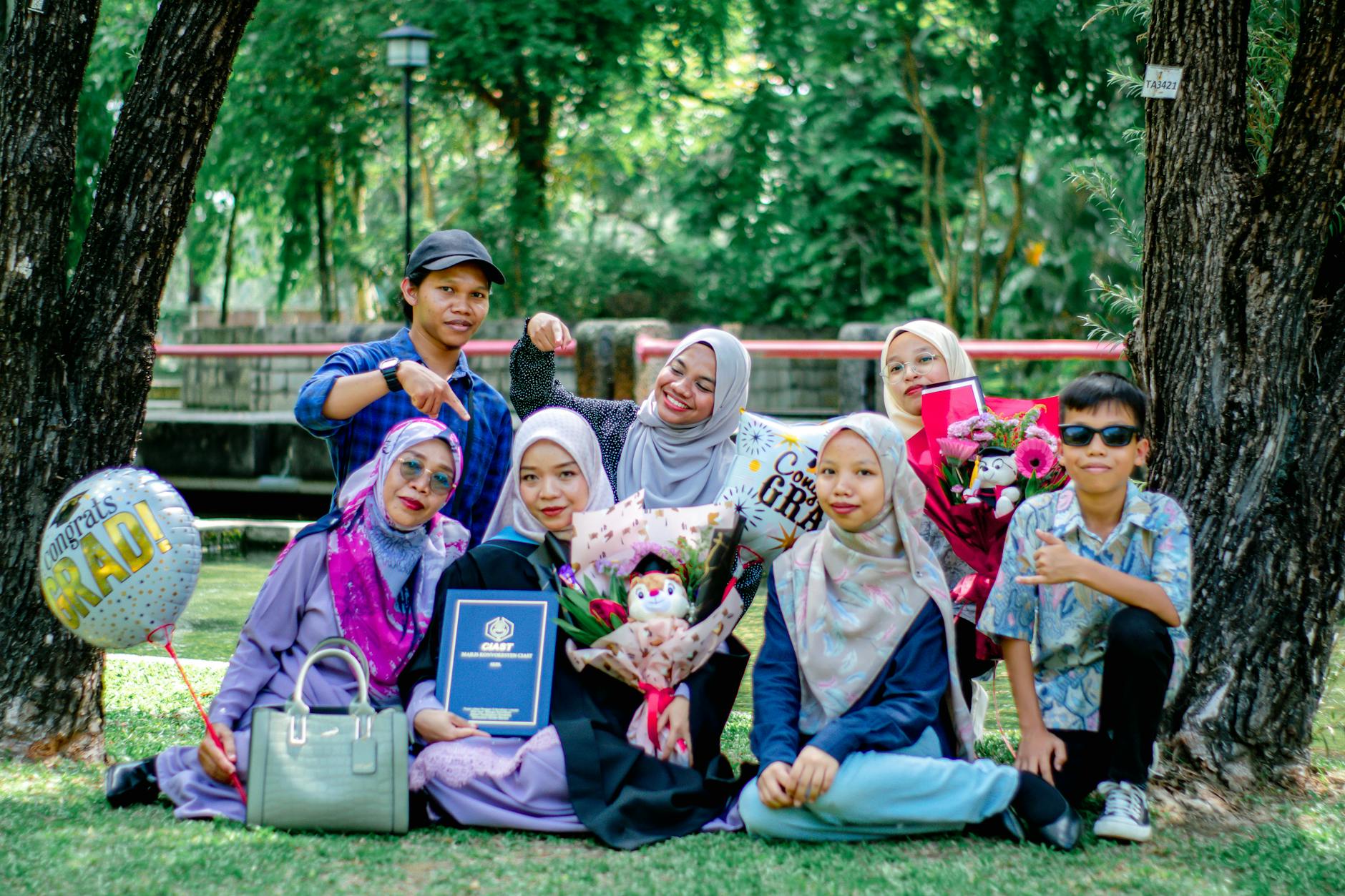 Group enjoying a joyous graduation ceremony in Shah Alam, Malaysia park.