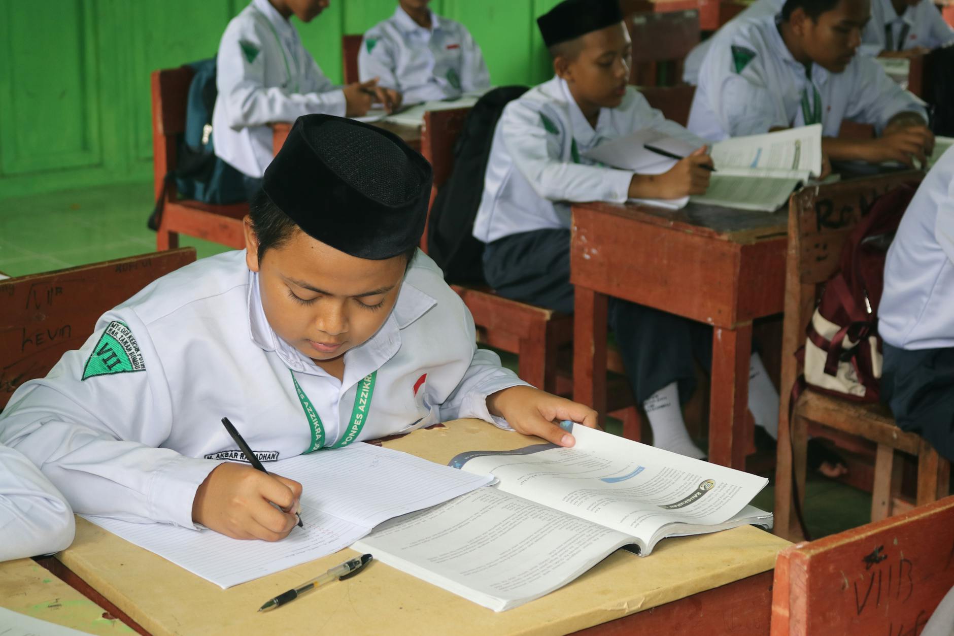Students writing and studying in a focused classroom environment.