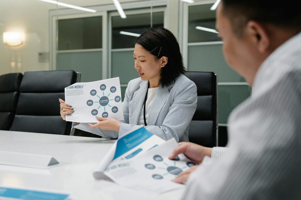 Colleagues in a modern conference room analyzing business reports and strategies during a meeting.