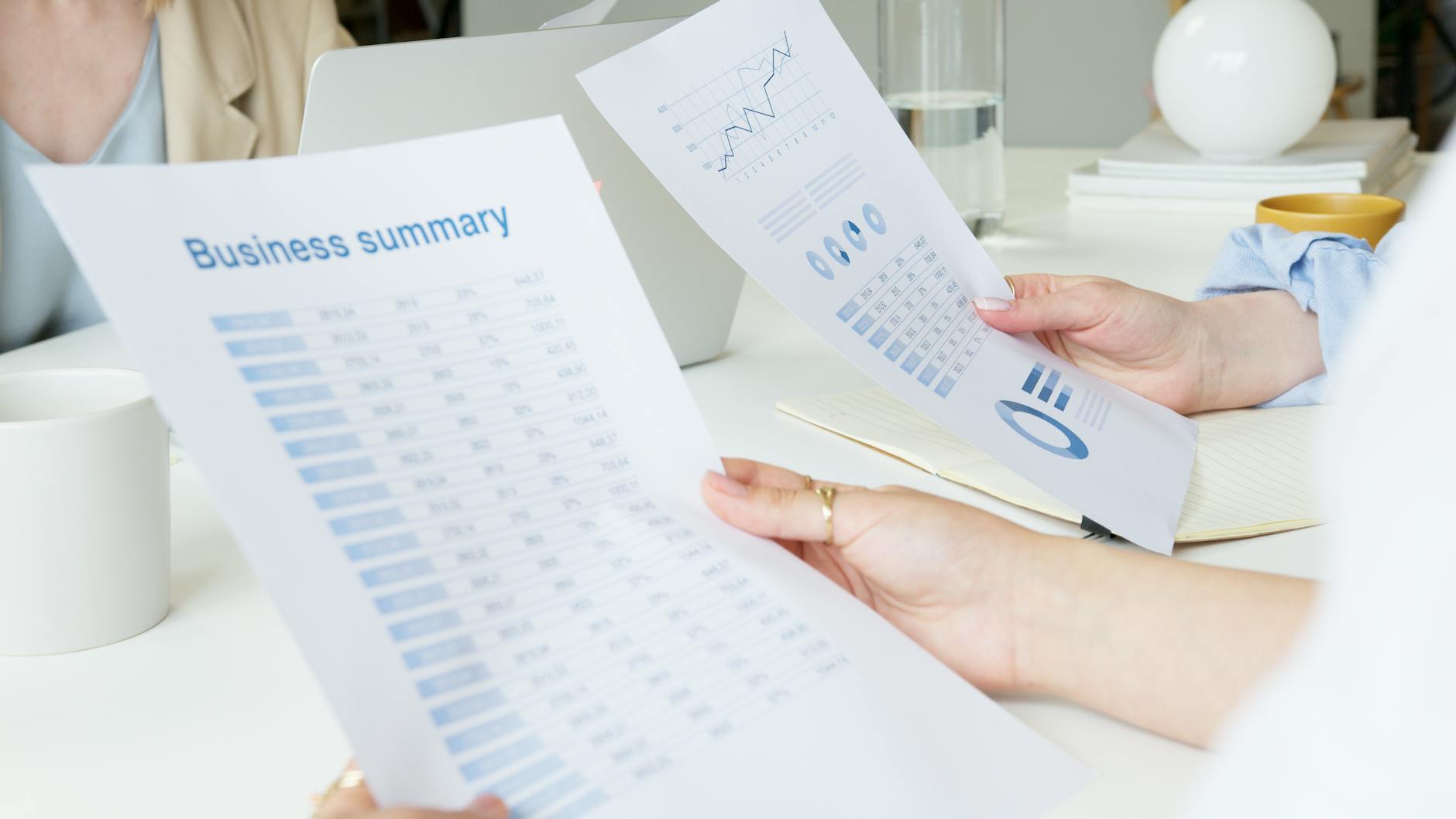 Two business professionals analyzing reports in a modern office setting.