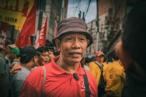 Street protest in Metro Manila, Philippines, featuring diverse people with banners and colorful attire.
