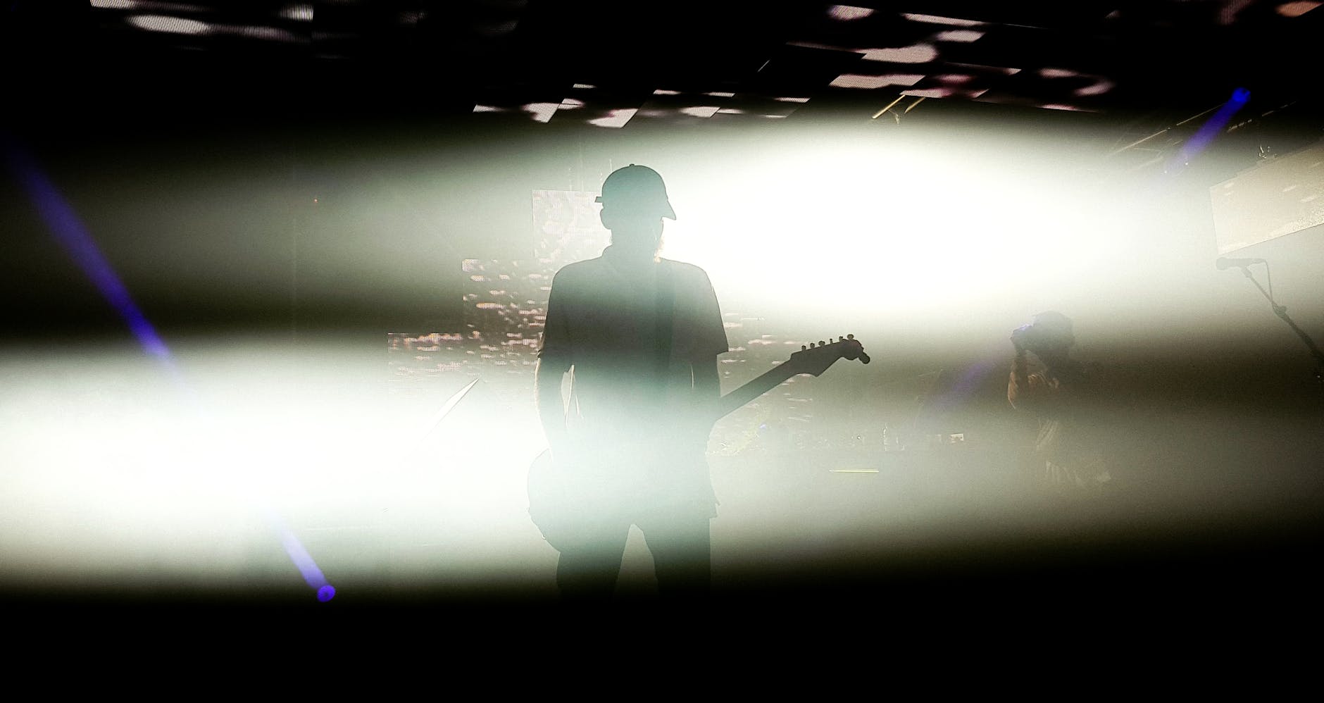 Silhouette of a guitarist performing under dramatic lighting, creating a striking stage presence.