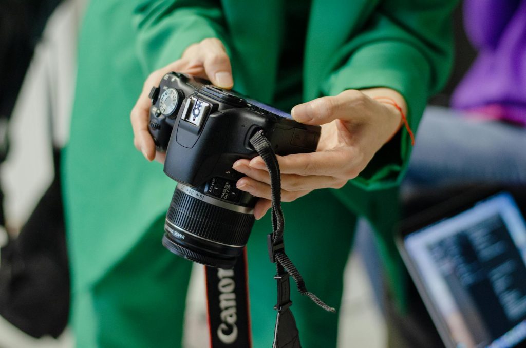 A close view of hands holding a DSLR camera, perfect for photography themes.