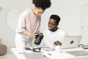 Professional photographers collaborating on a project with camera and laptop.