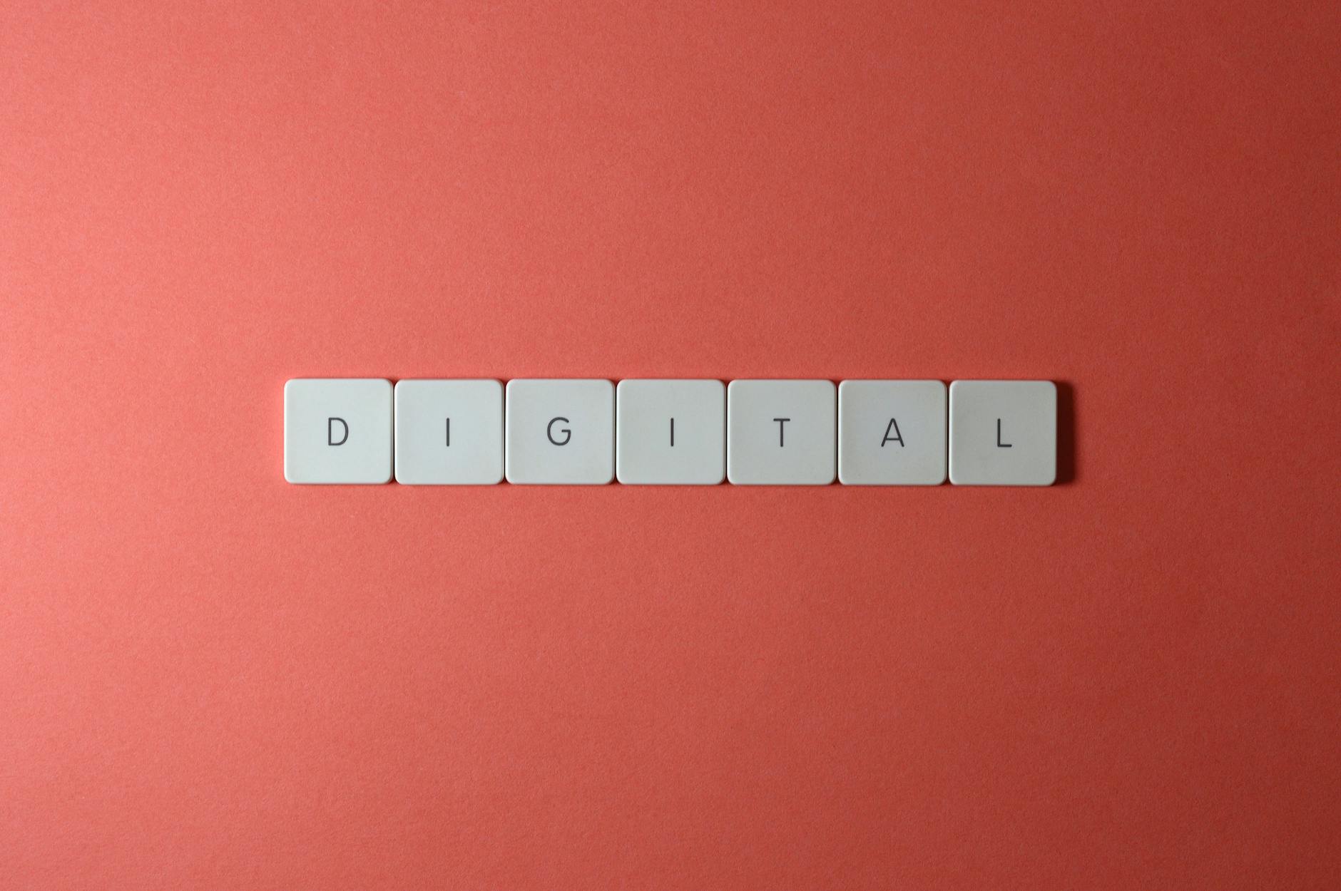 Close-up of keyboard tiles spelling 'DIGITAL' on a red background, perfect for tech themes.
