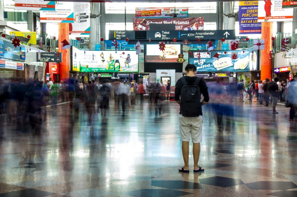 Busy scene at a train station in Kuala Lumpur with commuters in motion blur.