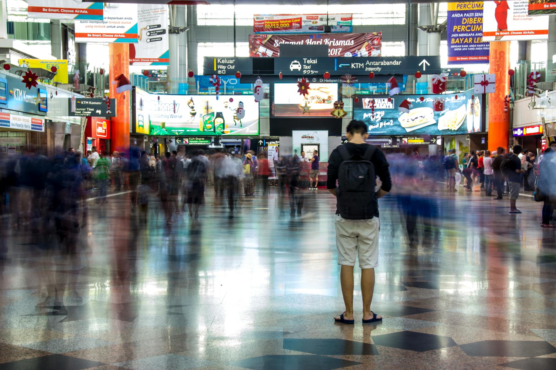 Busy scene at a train station in Kuala Lumpur with commuters in motion blur.