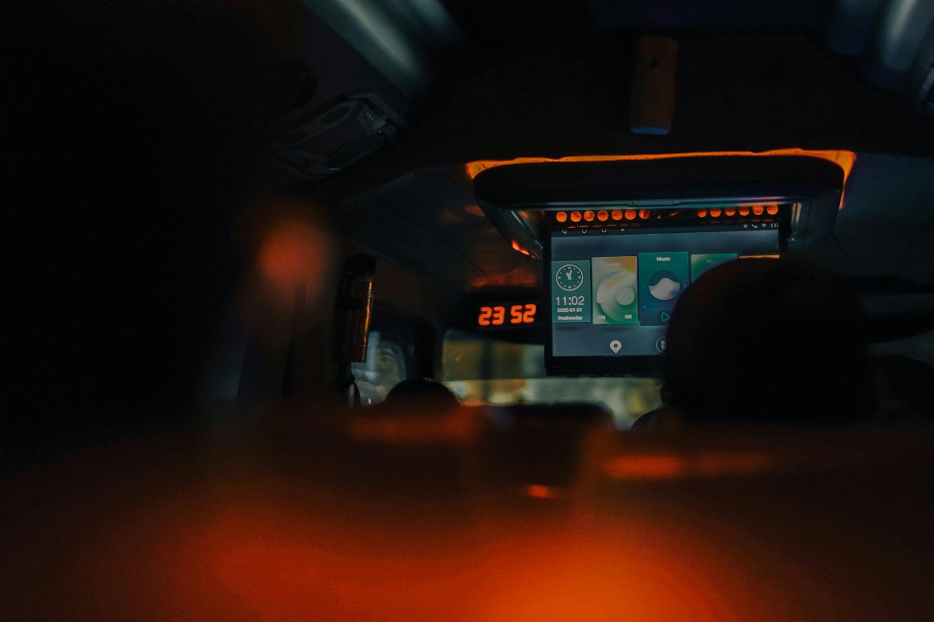 A dimly lit bus interior showcasing screens and ambient lighting during night travel.