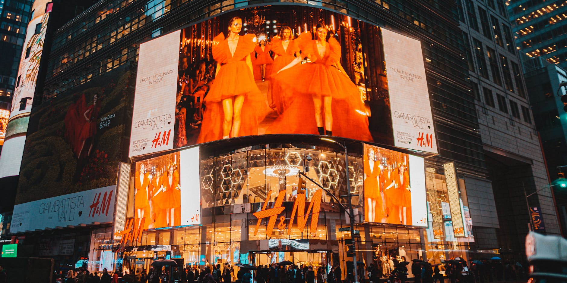 Times Square in NYC illuminated by H&M billboards, capturing urban nightlife and energy.