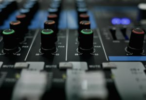 Detailed close-up of audio mixer knobs in a recording studio setting.
