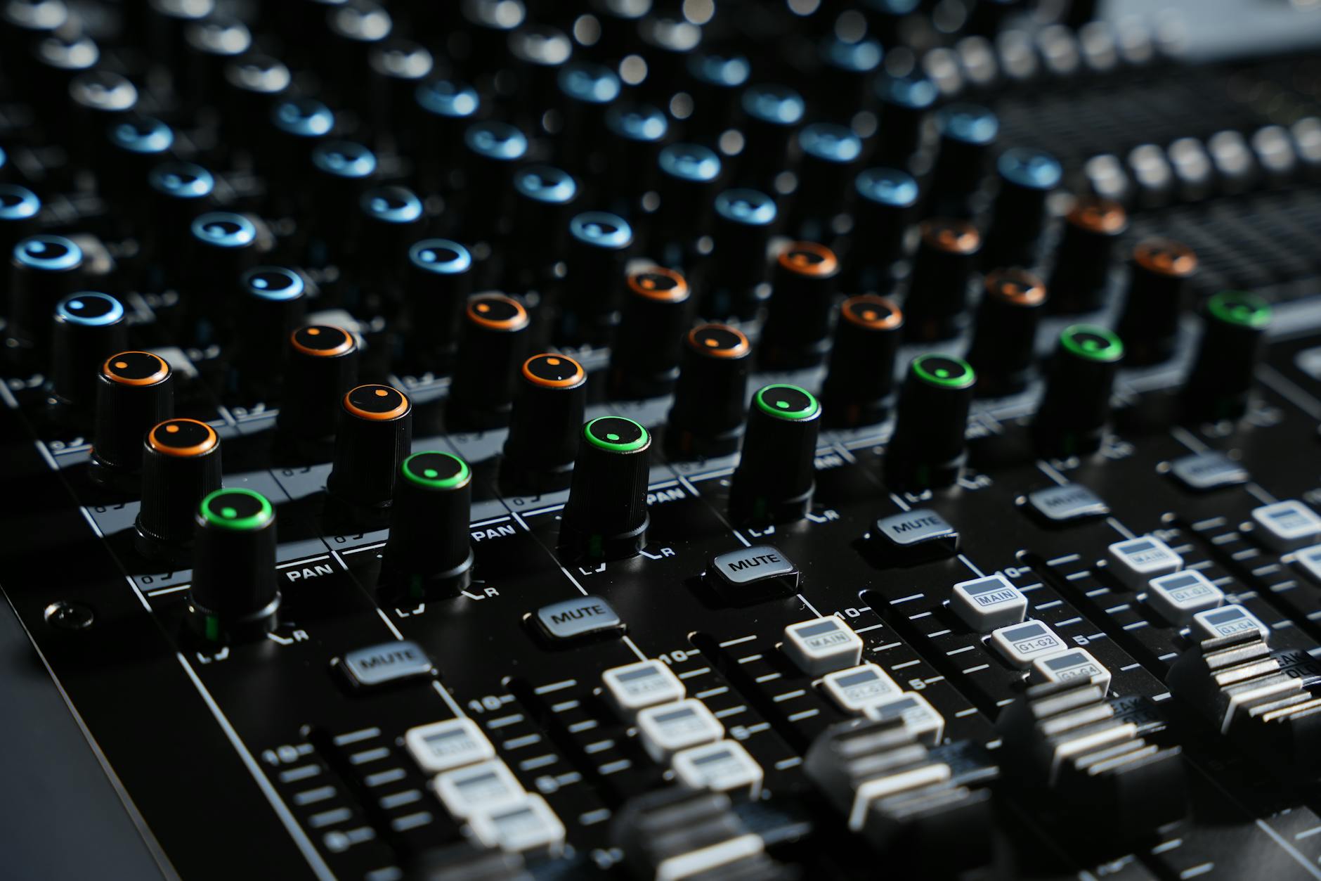 Detailed view of an audio mixing console with colorful lights in a professional studio setting.