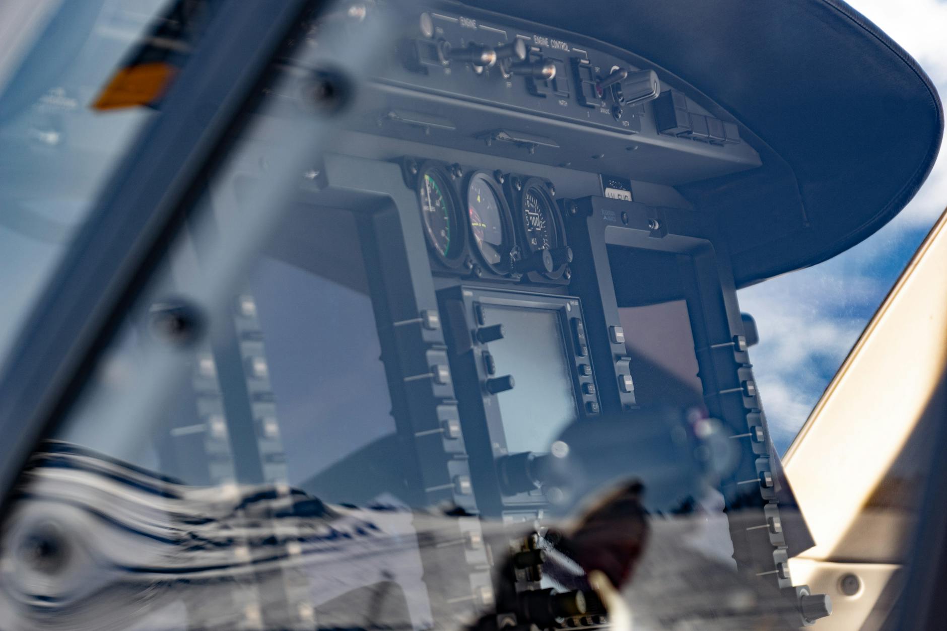 Close-up view of a modern airplane cockpit display with reflections on the glass.