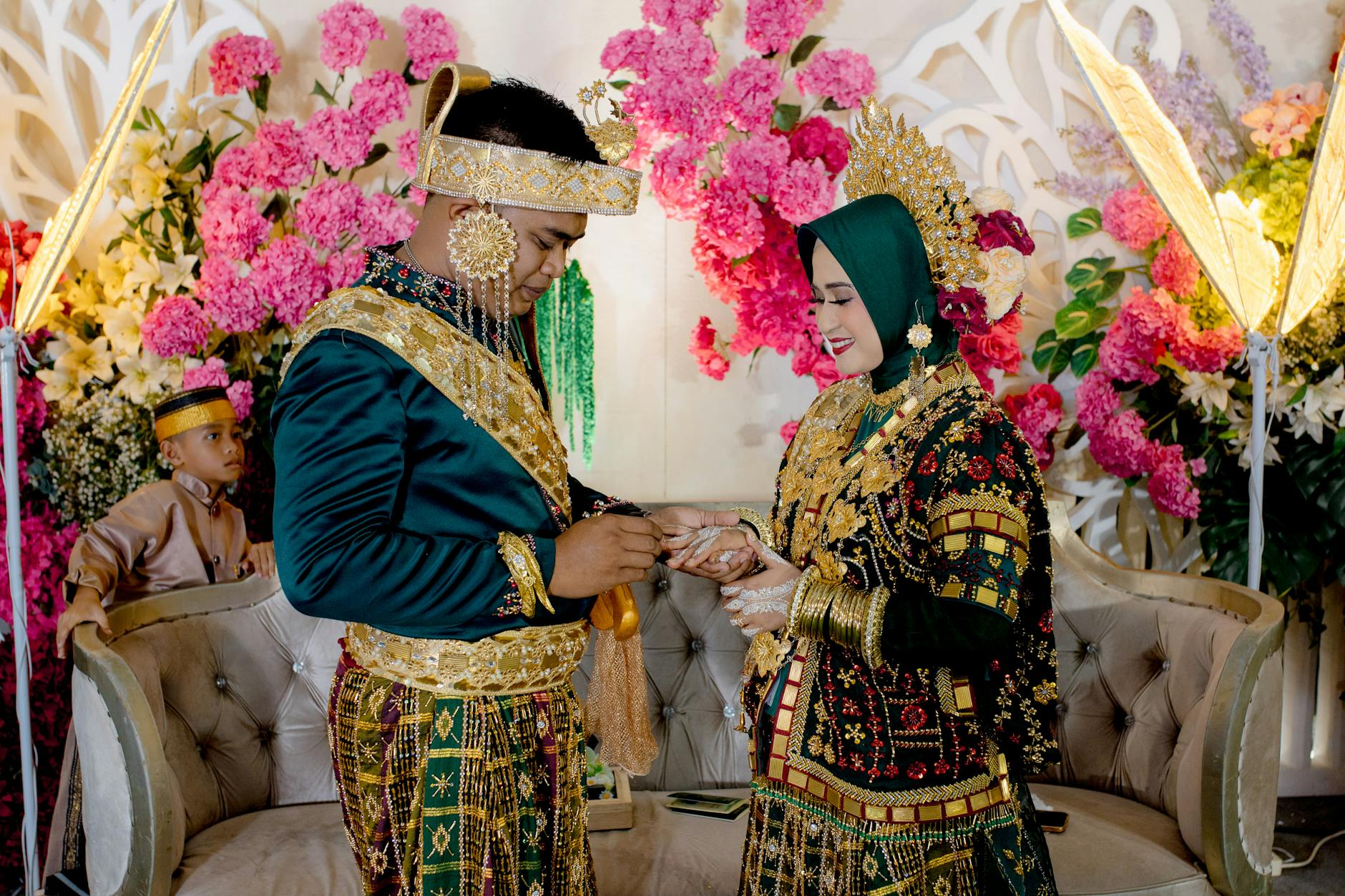 Couple exchanges rings in a vibrant traditional wedding ceremony in Kendari, Indonesia.