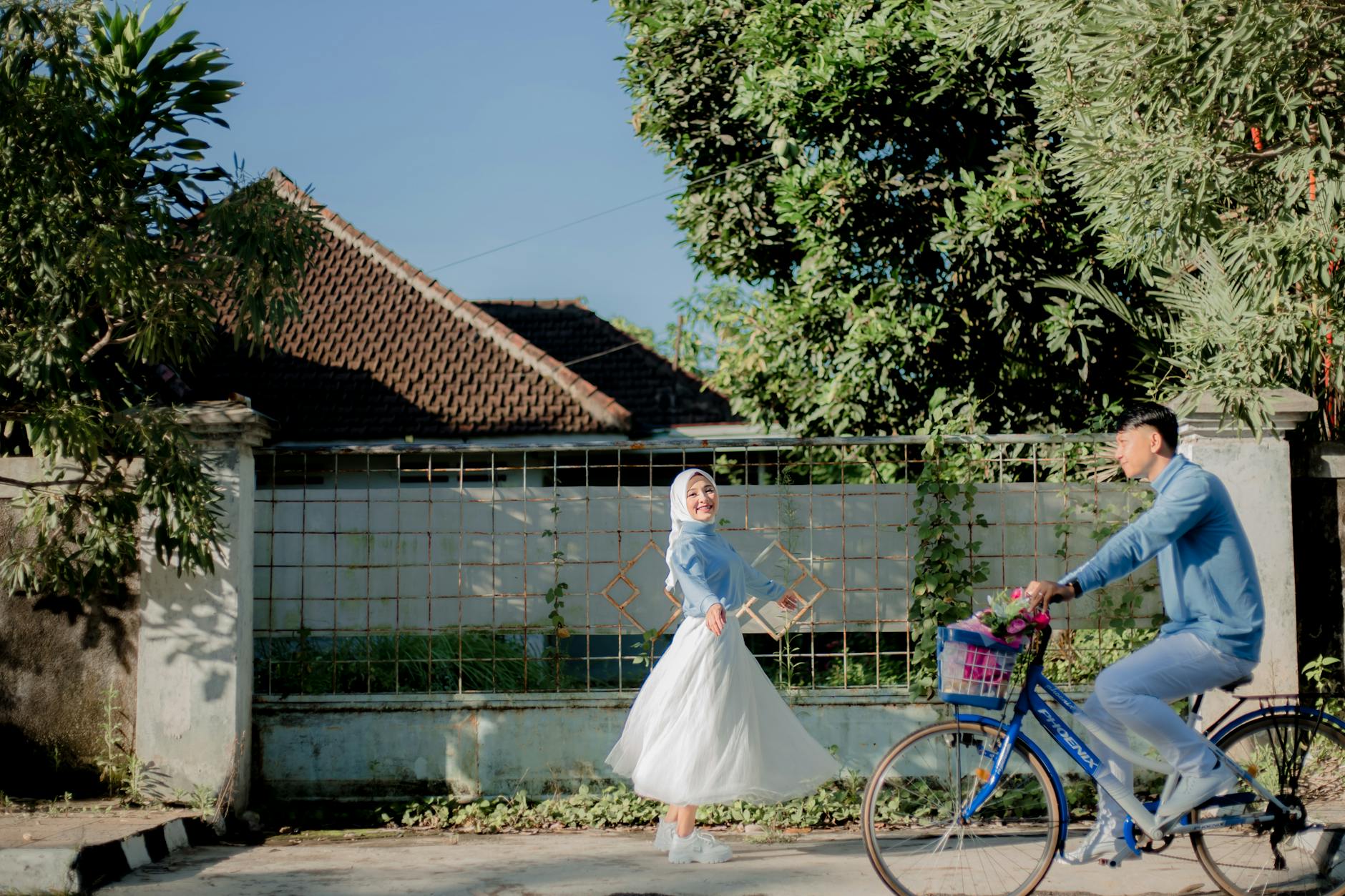 A joyful couple enjoying an outdoor pre-wedding photoshoot in Indonesia, with vibrant surroundings.