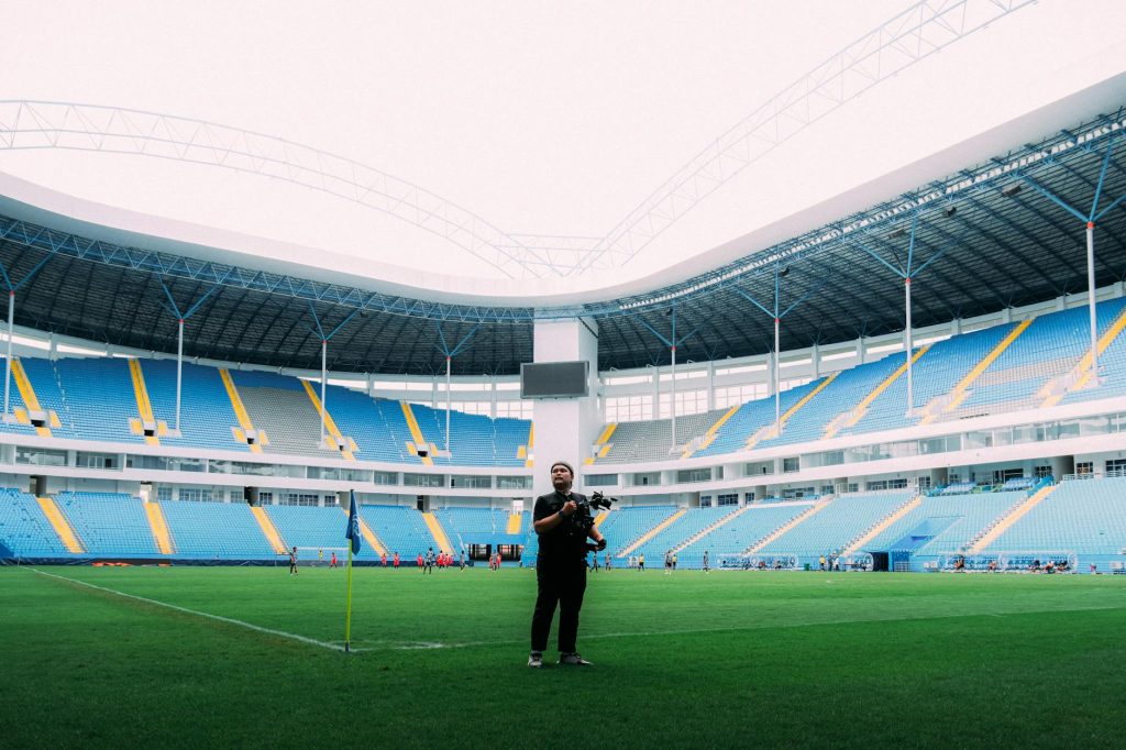 Photographer captures dynamic moment in a colorful football stadium.