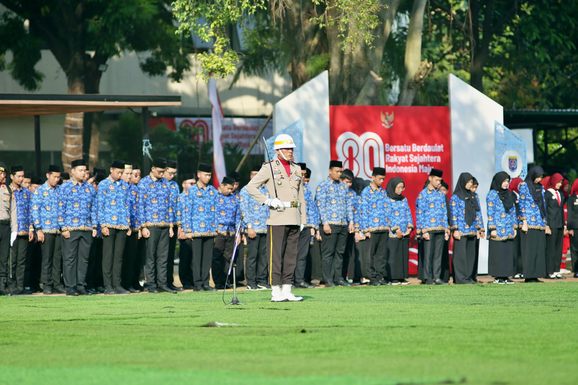 Indonesian event with participants in uniform during a flag ceremony outdoors.