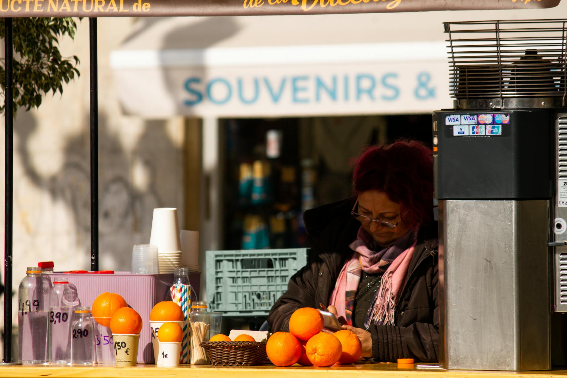 A vendor sells fresh orange juice at an outdoor market stall in Valencia, Spain.