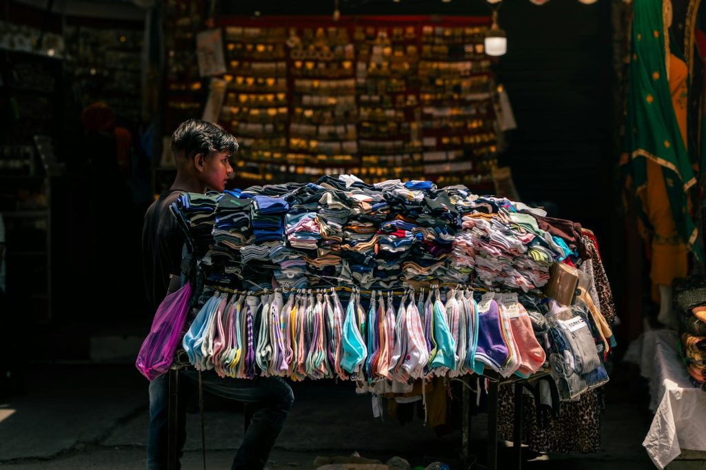 Portrait of a street vendor selling colorful clothes in a vibrant Jalandhar market, Punjab, India.
