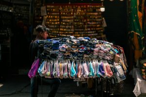 Portrait of a street vendor selling colorful clothes in a vibrant Jalandhar market, Punjab, India.