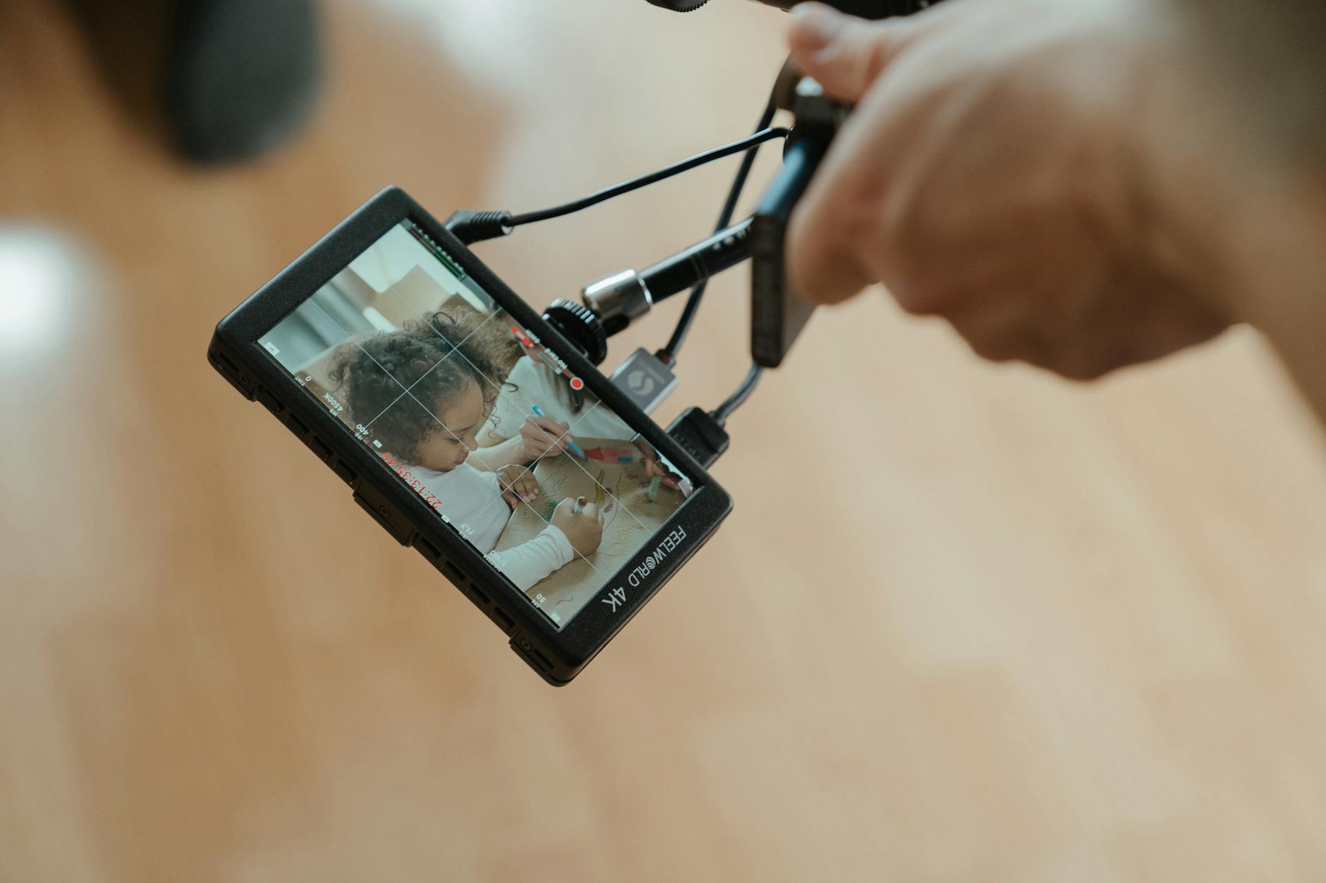 A camera monitor reveals a close-up shot of a child during filming, emphasizing creative processes.