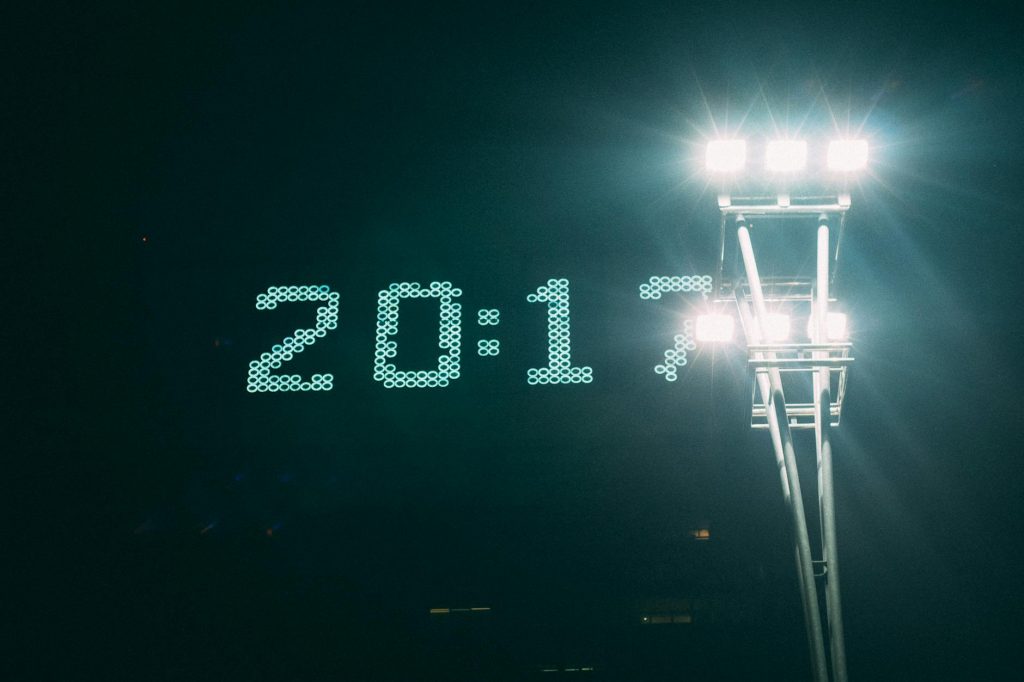 Illuminated digital clock and stadium lights creating a stunning visual contrast against the night sky.