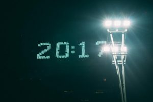 Illuminated digital clock and stadium lights creating a stunning visual contrast against the night sky.