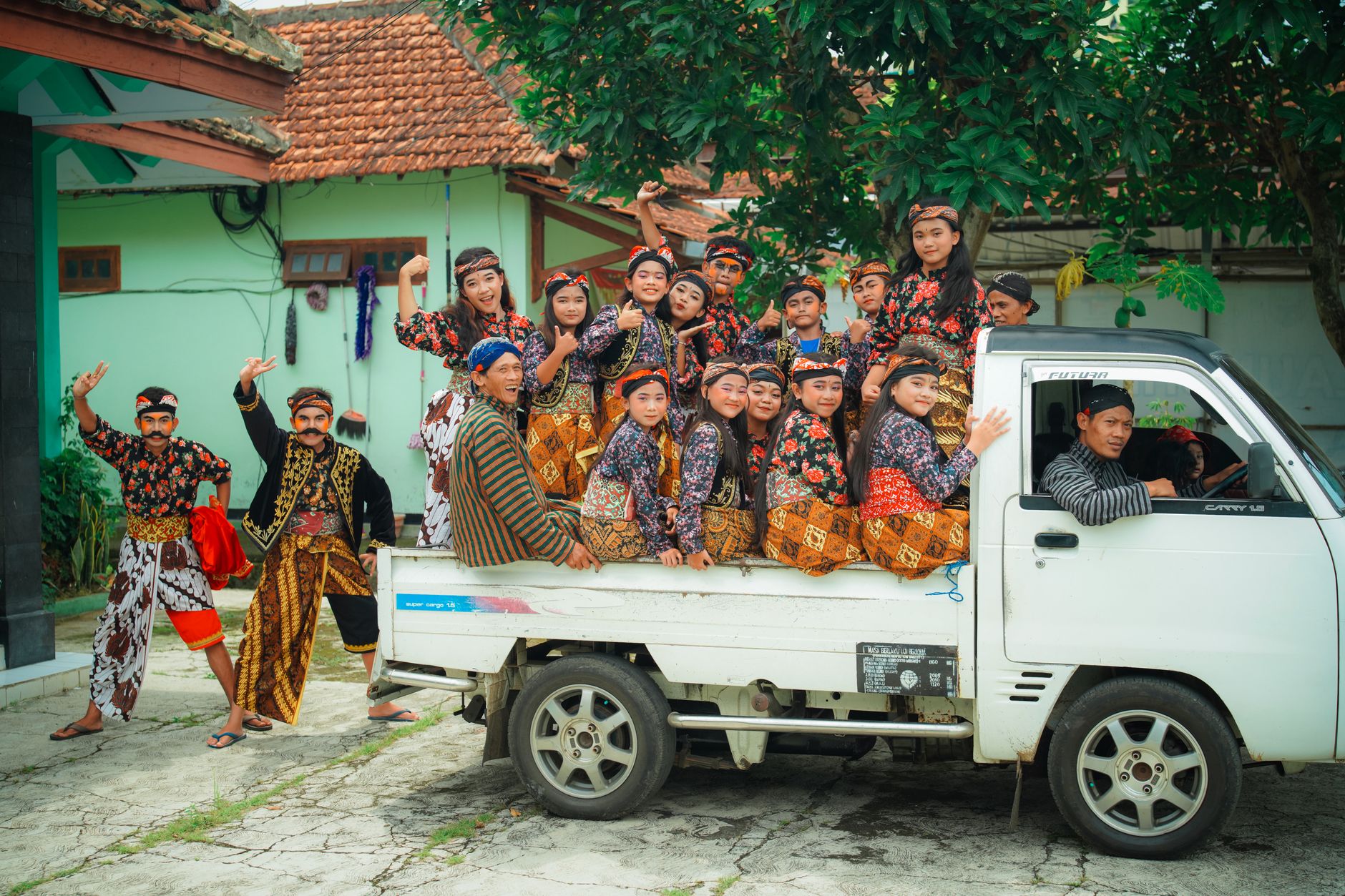 Group of traditional Javanese dancers, known as Jaranan, posing on a truck outdoors.