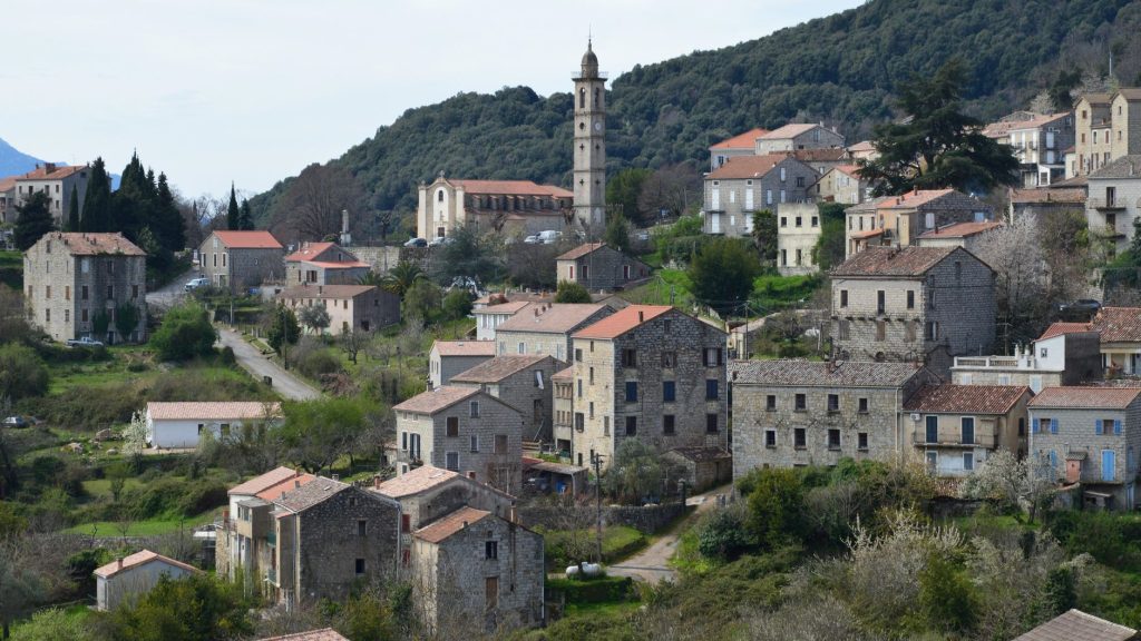 Scenic view of Levie village in Corse, France with traditional architecture and lush greenery.