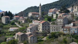 Scenic view of Levie village in Corse, France with traditional architecture and lush greenery.